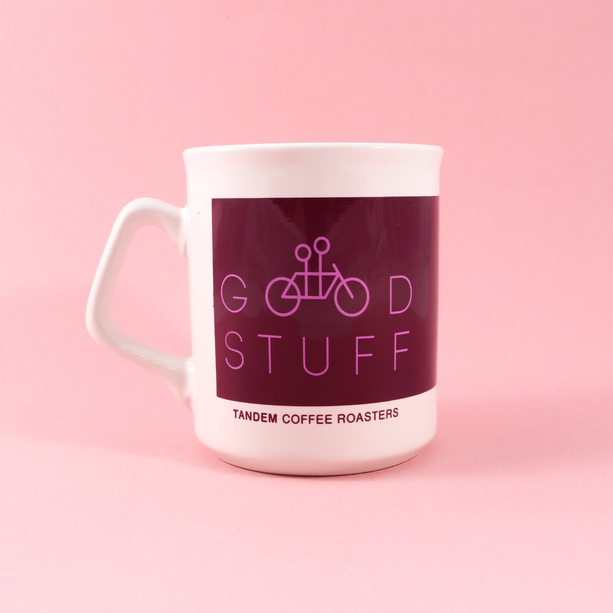 Good Stuff Mug #15 is an 11oz white ceramic coffee mug featuring a maroon rectangular graphic with a line-art tandem bicycle, the text GOOD STUFF, and TANDEM COFFEE ROASTERS printed at the bottom.