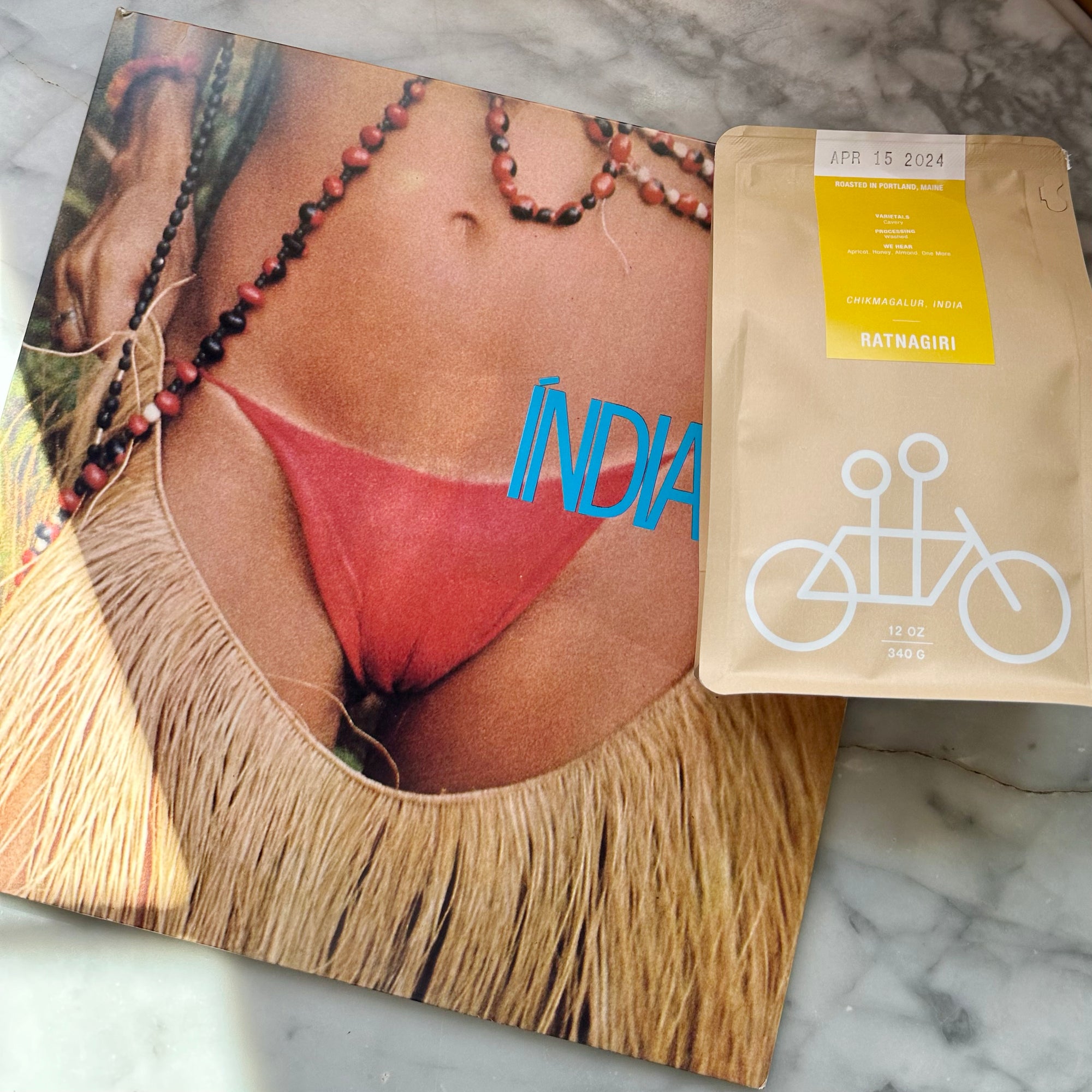 Tandem's The Good Thing - April 2024 Edition featuring a close-up image of a person wearing a red bikini bottom and a grass skirt, with necklaces and the word "India" superimposed, alongside a bag of limited edition coffee