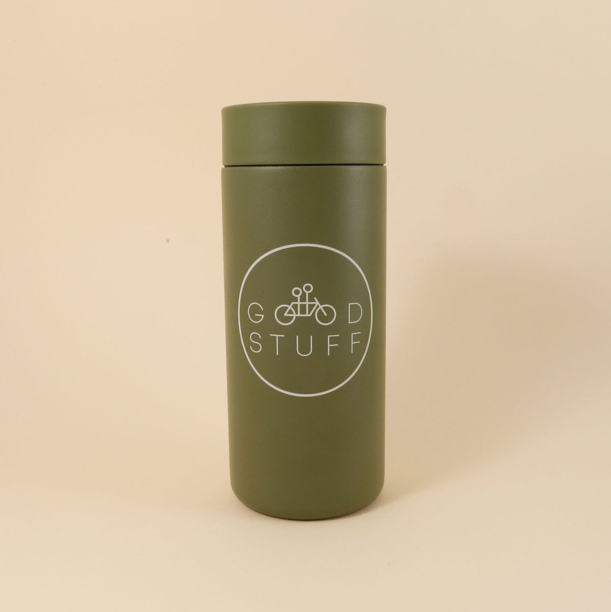 An MiiR 360 Traveler "GOOD STUFF" mug with a white logo featuring the text "good stuff" and a bicycle icon on a plain beige background.