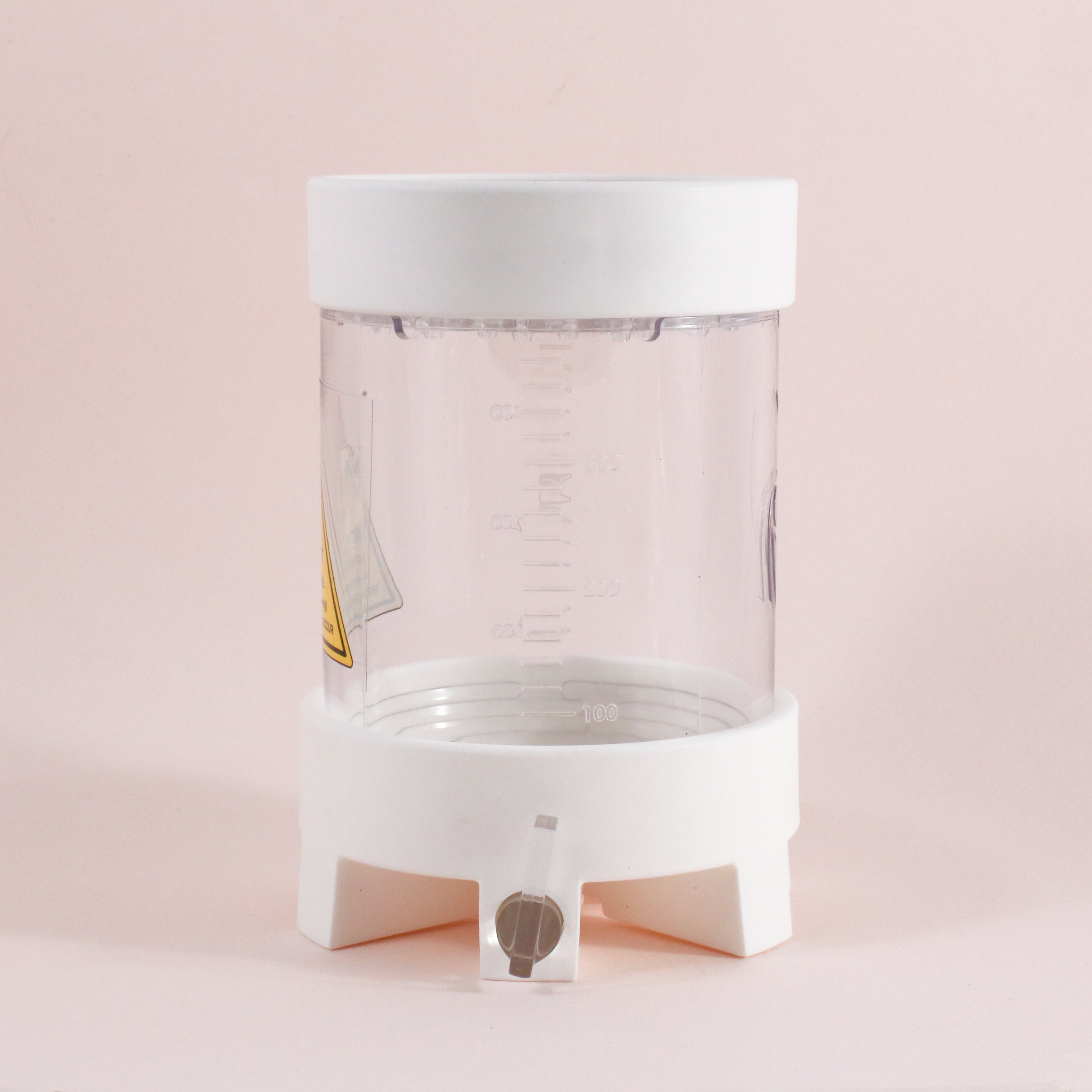 The NextLevel Pulsar Brewer by vendor-unknown is a clear plastic container with a white base and lid, graduated measurement marks, and a small spout with adjustable flow valve, shown against a light pink background.