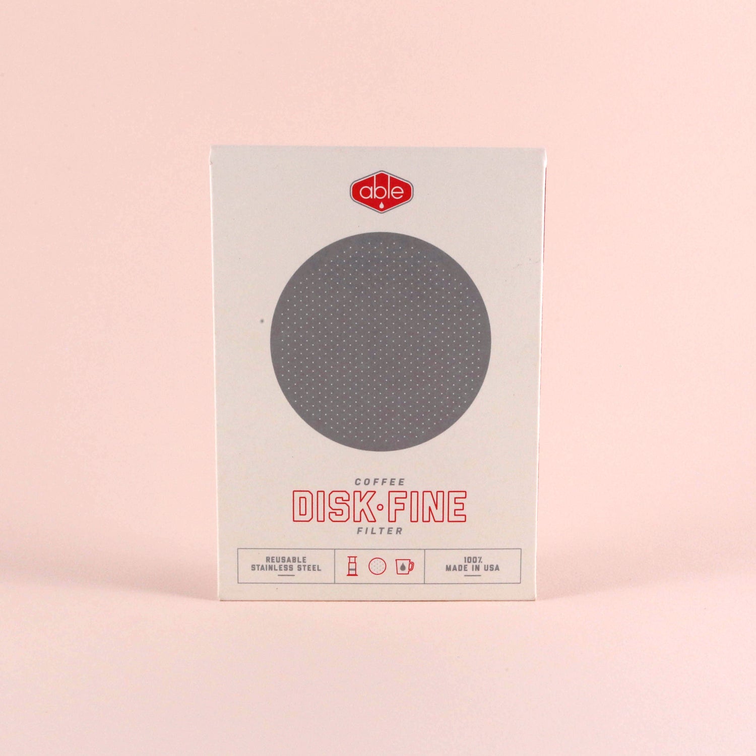 A Tandem Coffee Roasters Able Aeropress Filter Disk (Fine) designed for AeroPress is displayed in front of its packaging, which is labeled "disk fine," against a soft pink background.