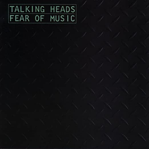 The album cover for "Talking Heads - Fear of Music," available from Tandem Coffee Roasters, features a black background with a diamond plate pattern. The album title and band name, set in green uppercase letters in the top left corner, capture the electric energy of tracks like "Life During Wartime.