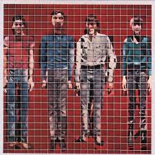 Four people stand side by side against a red backdrop in the style of the Talking Heads' "More Songs About Buildings and Food" album cover. Presented by Tandem Coffee Roasters, the image is pixelated into small squares, distorting their looks.