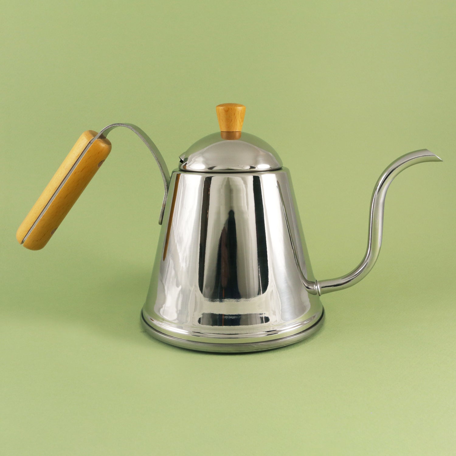 A shiny stainless steel pour over kettle with a wooden handle and a wooden knob on the lid, set against a solid light green background from Tandem Coffee Roasters.