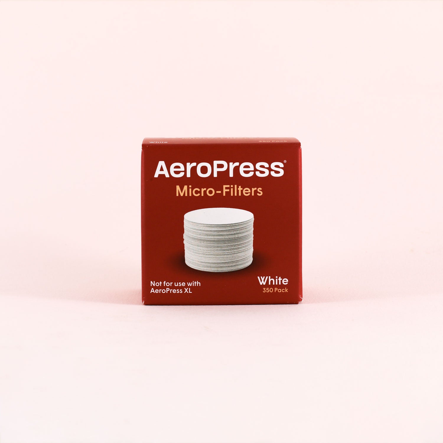 A red Tandem Aeropress Filters box displays white round filters on the front and reads "Not for use with AeroPress XL, White, 350 count" against a pale pink background.