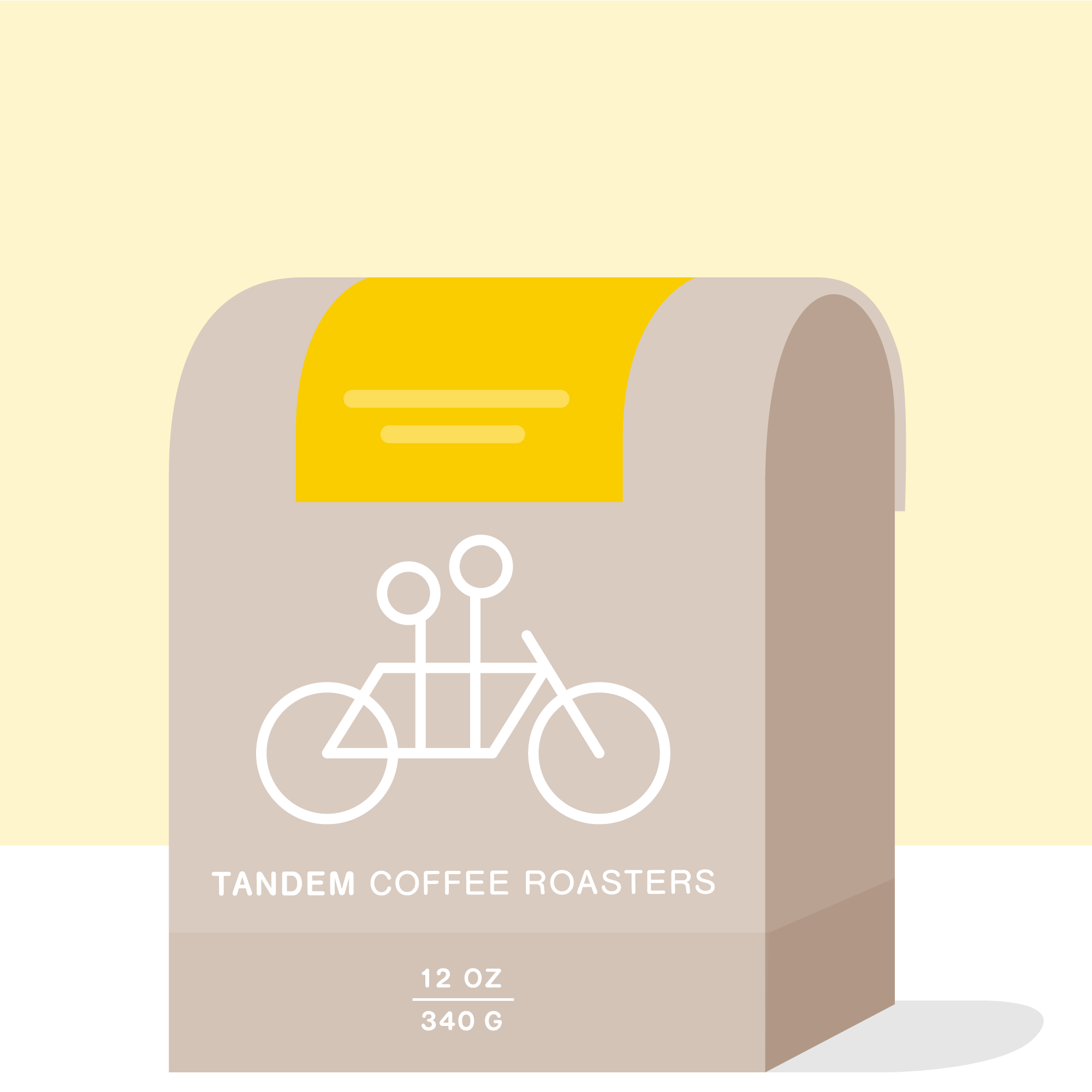A graphic of a gray coffee bag from Tandem Coffee Roasters, featuring a white tandem bicycle logo. The bag sits against a yellow background and is labeled "12 oz 340 g Ratnagiri - India".