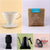 A collage of six images showcasing coffee equipment and products: a white ceramic Tandem Coffee Roasters V60 Deluxe Kit coffee dripper, a brown bag of freshly roasted La Piramide coffee beans, a black coffee grinder.