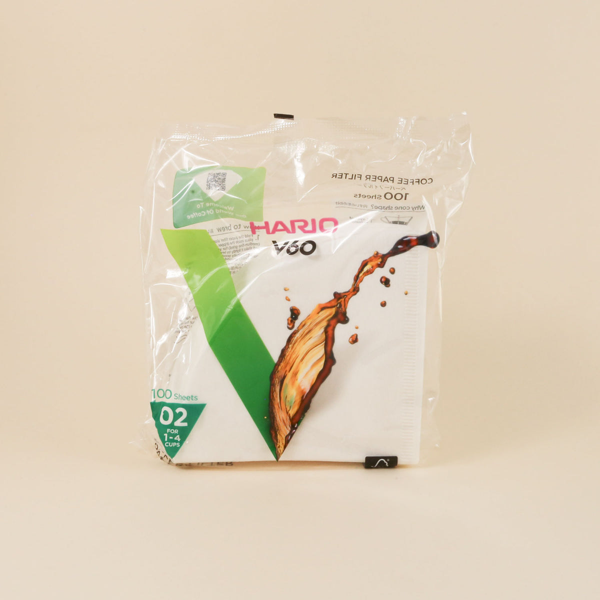 A sealed pack of Hario V60 Dripper Filters, size 02 for 100 sheets, with a white and green label featuring an image of a coffee splash.