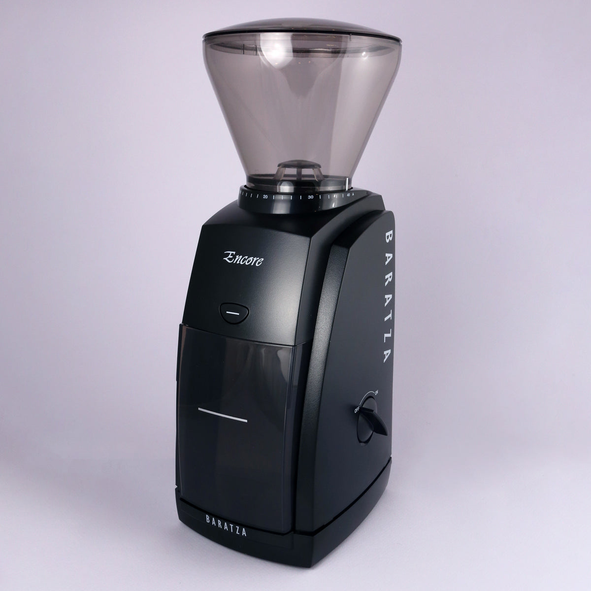 A black Tandem Baratza Encore Coffee Grinder with a transparent bean hopper on top, displayed against a plain, light purple background.