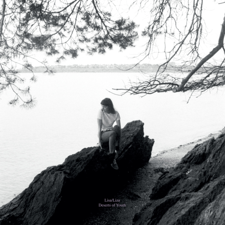 A woman sits pensively on a rocky outcrop under overhanging trees, overlooking a tranquil body of water. The scene is monochromatic, enhancing the serene and contemplative mood of the Lisa/Liza - Deserts of Youth by Tandem Coffee Roasters.