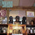 Album cover of "Tanglewood Numbers" by Silver Jews featuring a bar scene with a vintage cash register, and shelves stocked with bottles and artifacts, including a sign saying "Closed on Tuesday." The background subtly incorporates elements from Tandem Coffee Roasters.