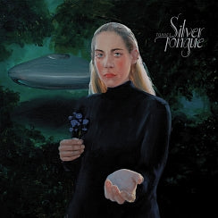 A woman stands in a dark, forest-like setting holding a small bouquet and an egg, looking solemnly at the viewer, with a UFO hovering in the background. The text above reads "TANDEM COFFEE ROASTERS - SILVER TONGUE